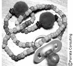 Photograph of a beaded necklace with a pacifier attached.