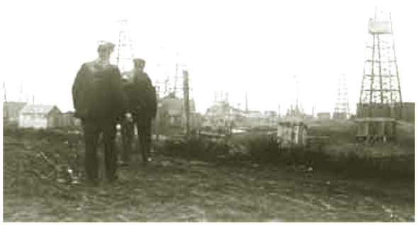 Photo of two men walking in an oil field