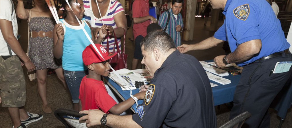 An image of a police officer with a young boy at a police community-event.