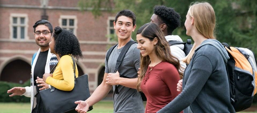 A group of diverse college students walking on a college campus