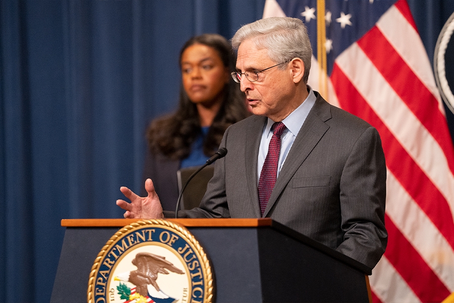 Attorney General Merrick B. Garland delivers remarks from a podium bearing The Department of Justice seal.