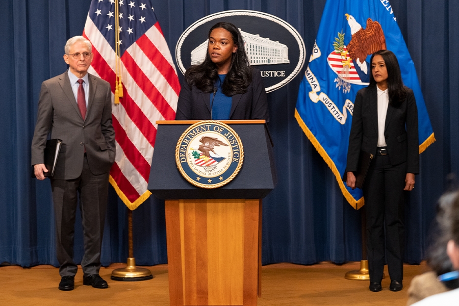 Principal Deputy Assistant Attorney General Doha Mekki delivers remarks from a podium bearing The Department of Justice seal.