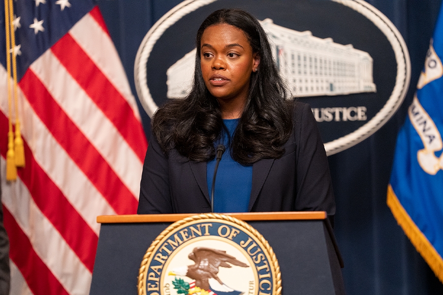 Principal Deputy Assistant Attorney General Doha Mekki delivers remarks from a podium bearing The Department of Justice seal.