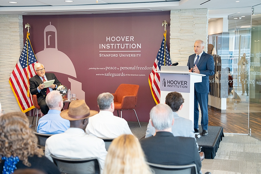 Assistant Attorney General Matthew G. Olsen stands at a podium at the Hoover Institution in Washington, D.C. delivering remarks to an audience.