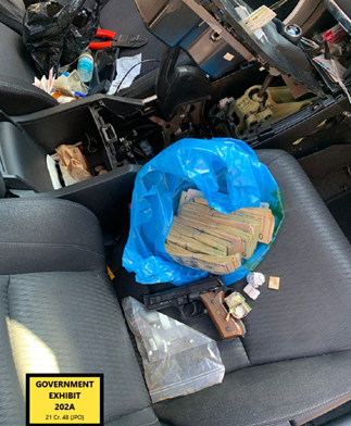 Picture of a handgun, cash, and fentanyl hidden in the defendant’s car