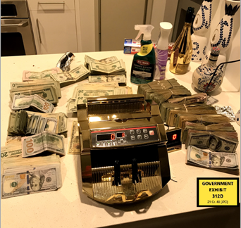 Picture of a gold money counter and cash found in the defendant’s residence