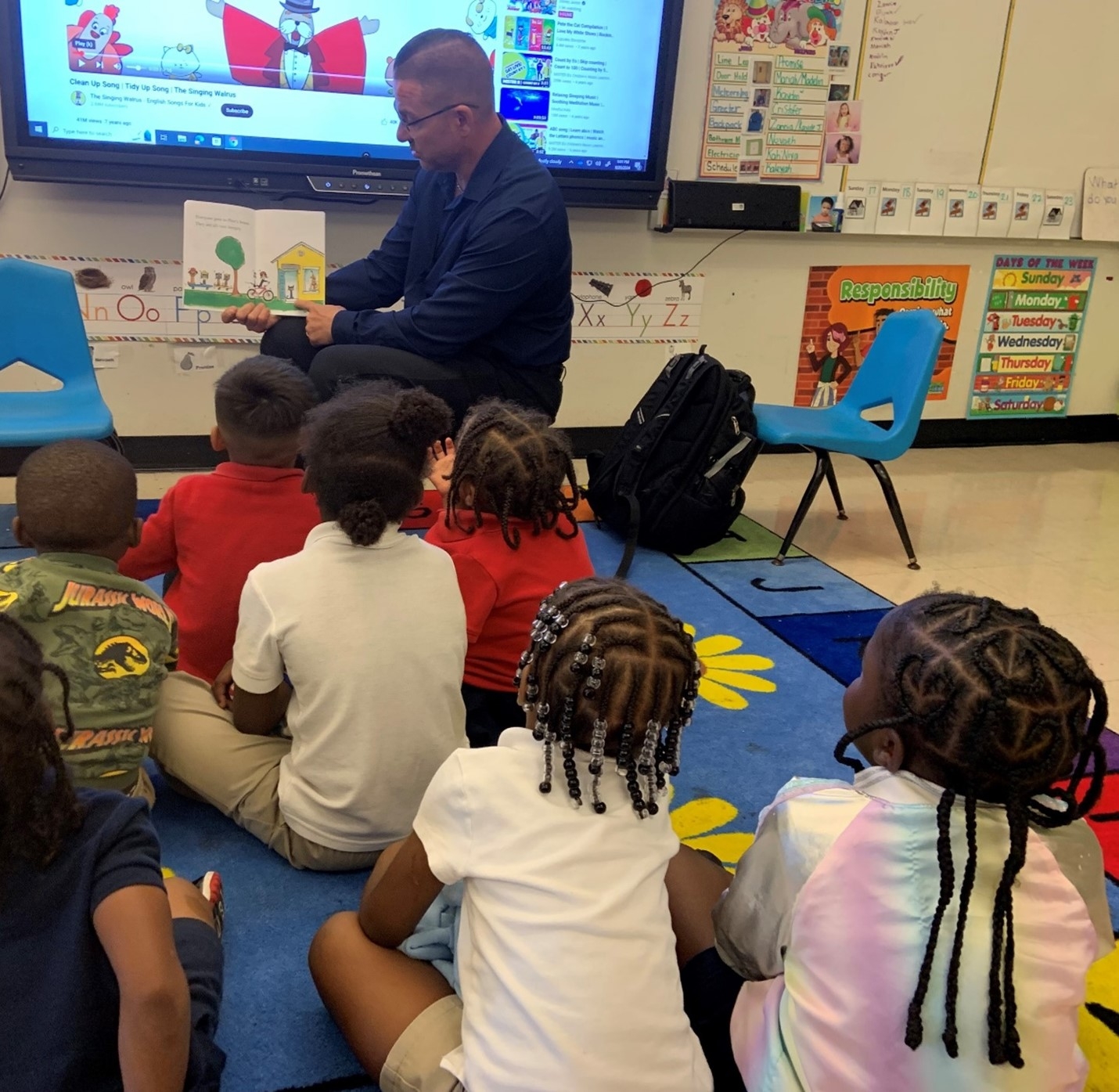 Community Outreach Specialist Corey Mackay, Law Enforcement Coordination and Community Outreach Section of the U.S. Attorney’s Office, reads books to pre-K students at Holmes Elementary School in Liberty City  in an effort to foster a love of reading. 