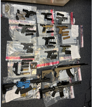 Photo of 13 firearms, magazines, ammunition, and a lower receiver seized from the home where the defendant was staying