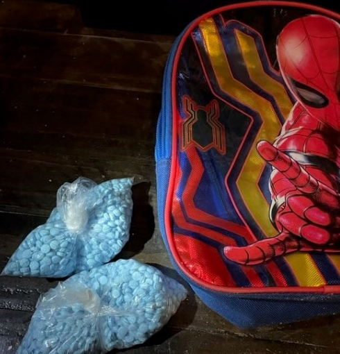 Drugs in a baggie next to a spider man backpack