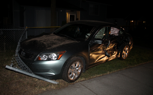 A car smashed up on a chain link fence 