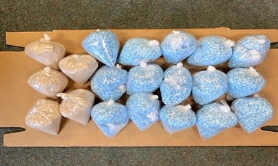 Image of blue and orange pills in plastic bags.