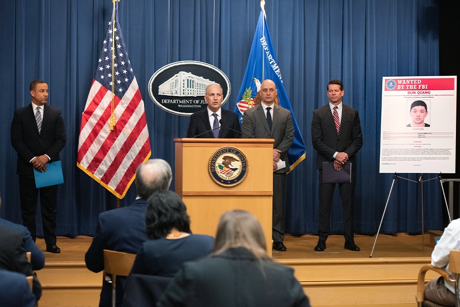Assistant Attorney General Matthew G. Olsen addresses reporters from a podium at the Department of Justice