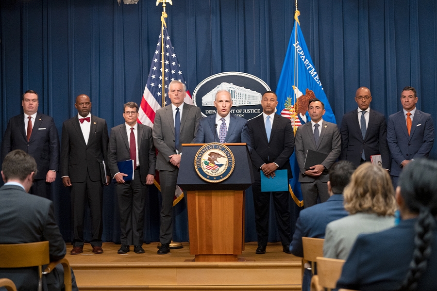 Assistant Attorney General Matthew G. Olsen of the Justice Department's National Security Division delivers remarks from a podium bearing the Department of Justice seal