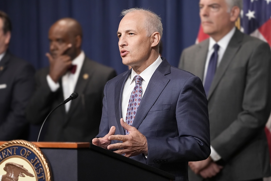 Assistant Attorney General Matthew G. Olsen of the Justice Department's National Security Division delivers remarks from a podium bearing the Department of Justice seal