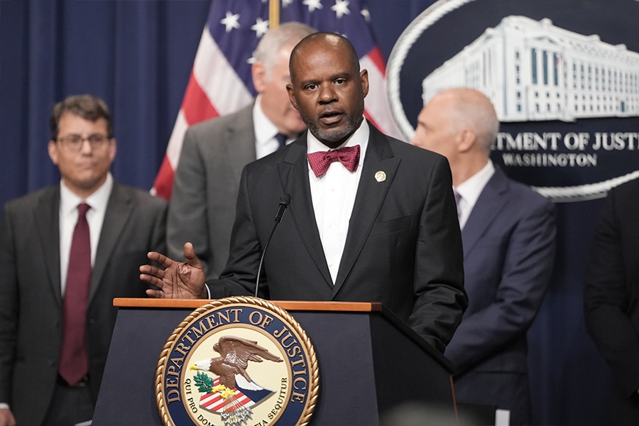 U.S. Attorney Ismail J. Ramsey for the Northern District of California delivers remarks from a podium bearing the Department of Justice seal