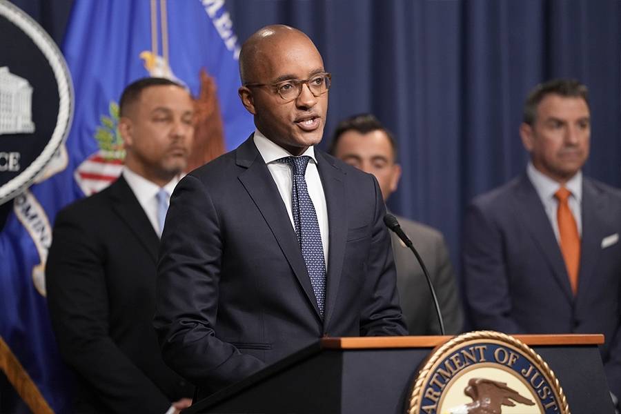 U.S. Attorney Damian Williams for the Southern District of New York delivers remarks from a podium bearing the Department of Justice seal