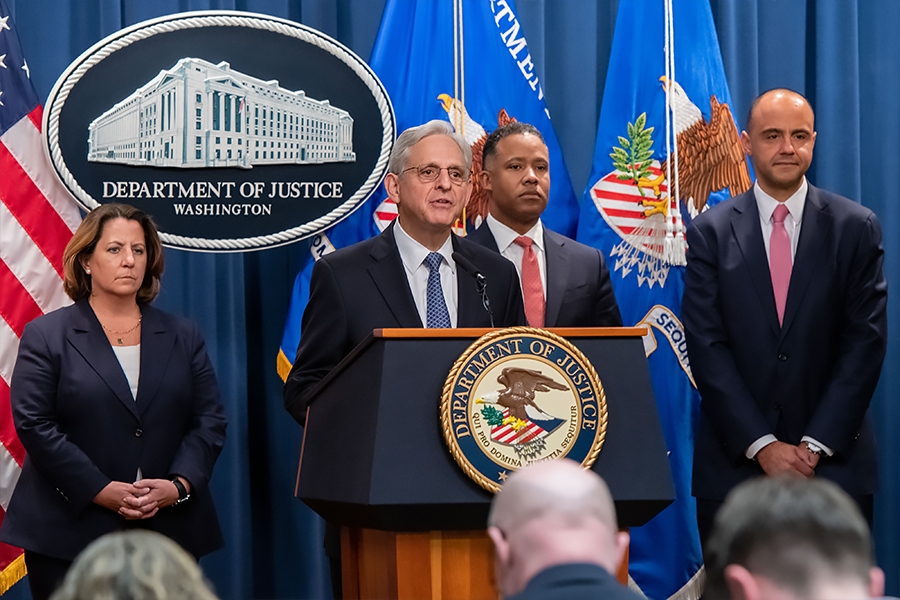 Attorney General Merrick B. Garland delivers remarks from a podium bearing the Department of Justice seal