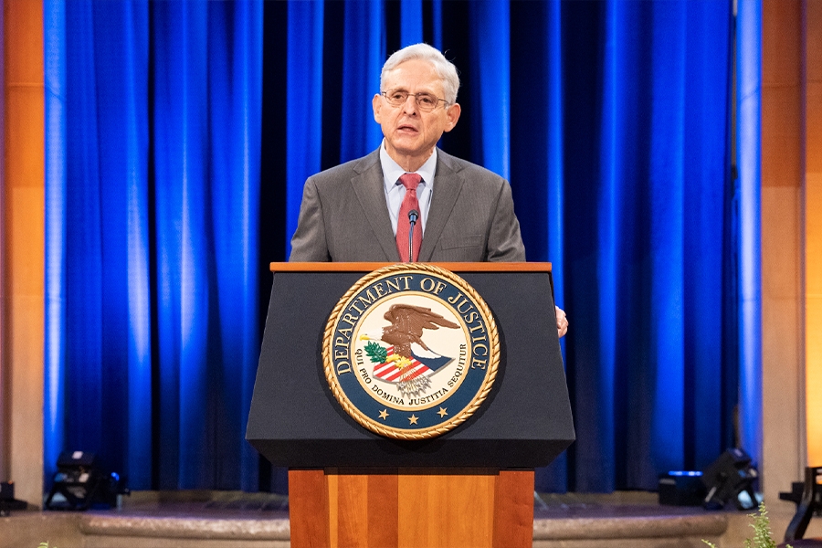 Attorney General Merrick B Garland delivers remarks from a podium in the Great Hall at the Department of Justice.
