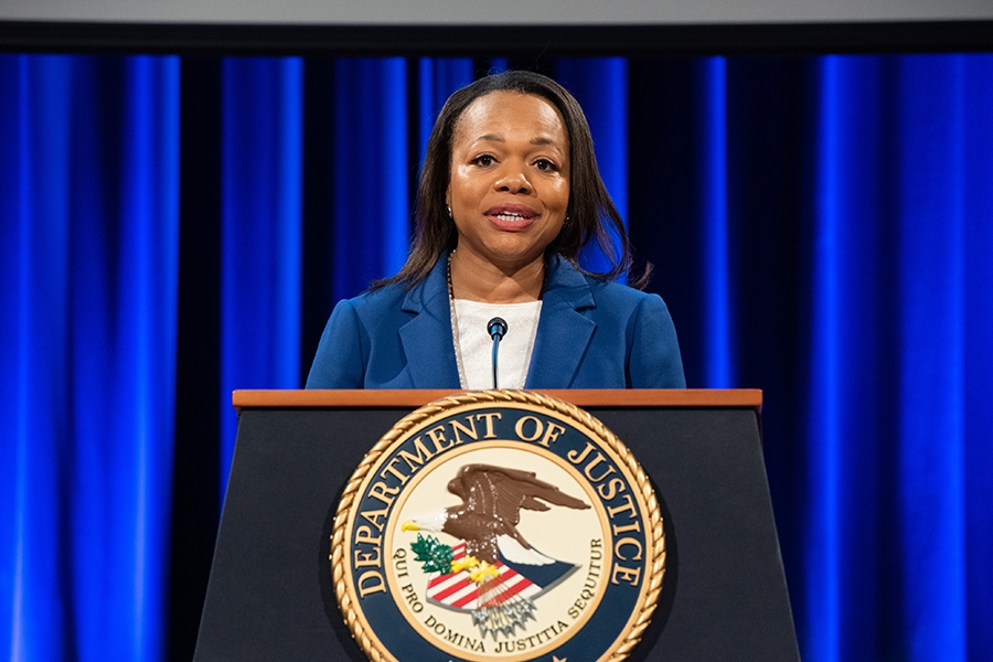Assistant Attorney General for Civil Rights Kristen Clarke delivers remarks from a podium in the Great Hall at the Department of Justice.