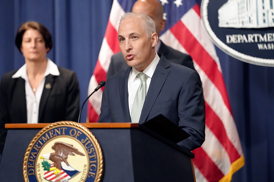 Assistant Attorney General for National Security Matthew G. Olsen delivers remarks from a podium bearing the Department of Justice seal.