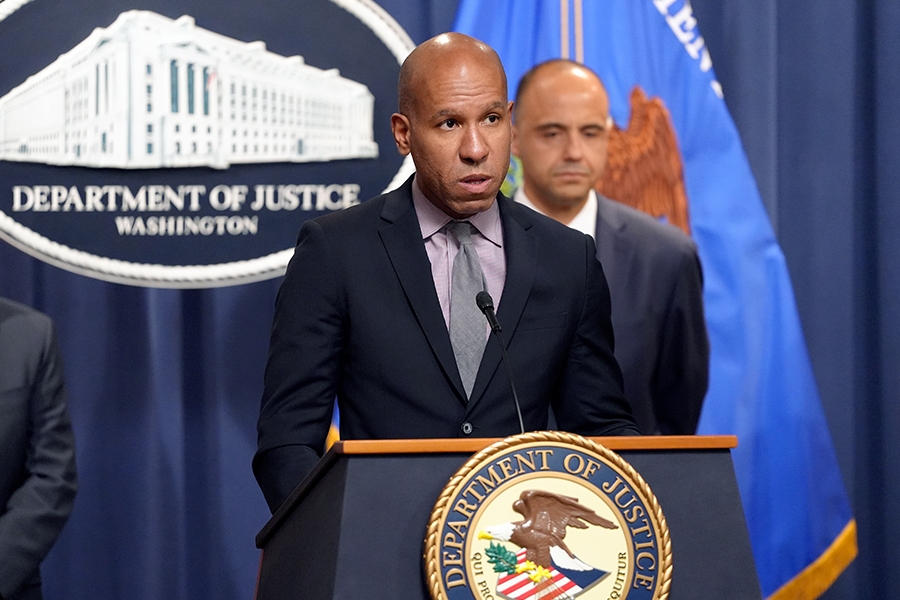 Under Secretary of the Treasury for Terrorism and Financial Intelligence Brian E. Nelson delivers remarks from a podium bearing the Department of Justice seal.