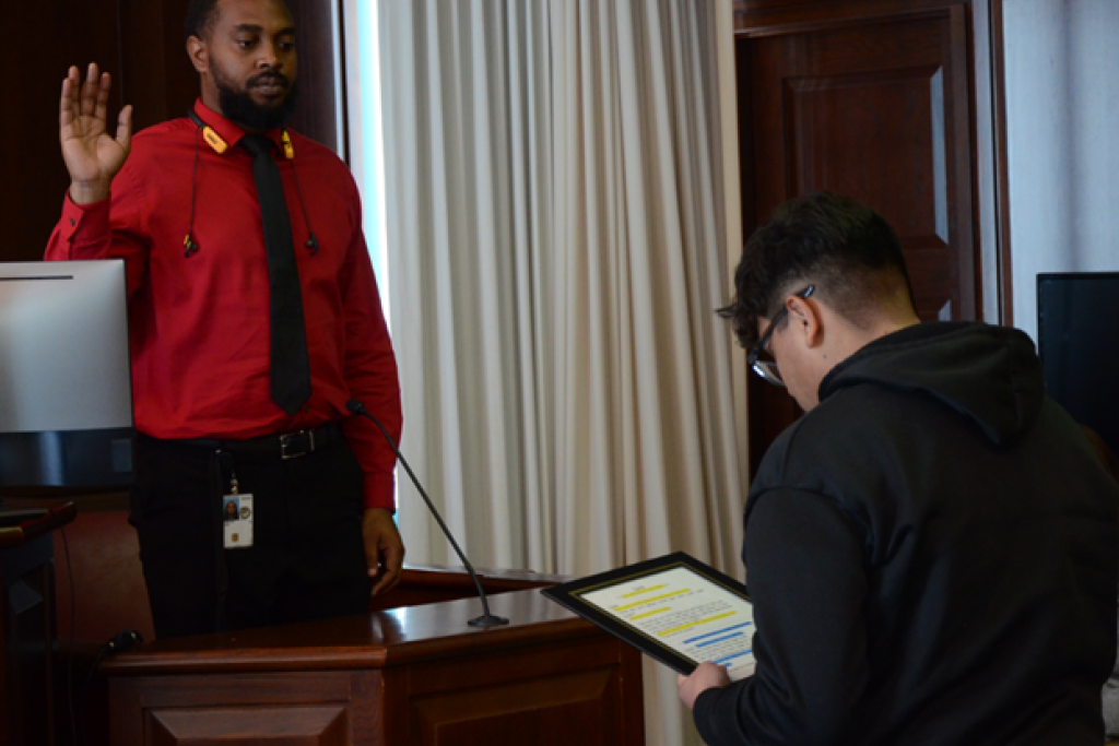 Community Outreach Specialist John Hampton gets sworn in by a Bowman Ashe/Doolin K-8 Academy student prior to testifying during a recent mock trial.