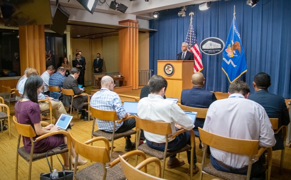 Attorney General Merrick B. Garland speaks to press and media at a podium bearing the Department of Justice seal.