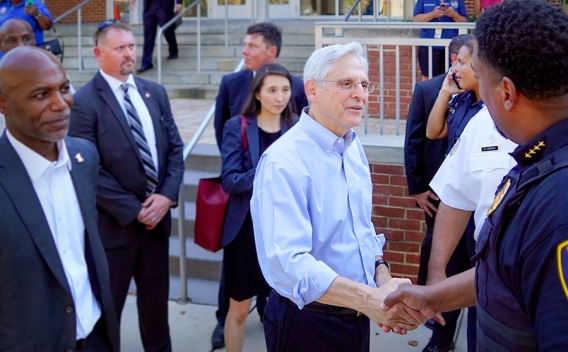 Attorney General Merrick B. Garland shakes hands with law enforcement officers on National Night Out in Baltimore, M.D.