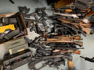 piles of various guns and parts on the floor