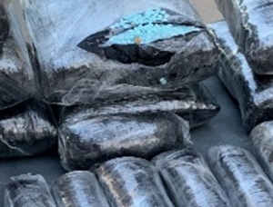Close up of one of the 21 packages discovered by Pinal County deputies. The package is cut open revealing blue pills stamped M30. The package was hidden underneath the rear seat floorboard.