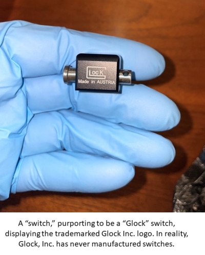 Image of a machinegun conversion device, commonly referred to as a, “switch,” in someone’s hand. Text reads: A “switch,” purporting to be a “Glock” switch, displaying the trademarked Glock Inc. logo. In reality, Glock, Inc. has never manufactured switches.