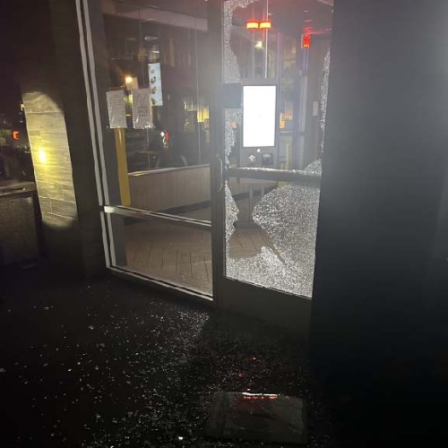 Photo of a glass door, with the bottom panel shattered.