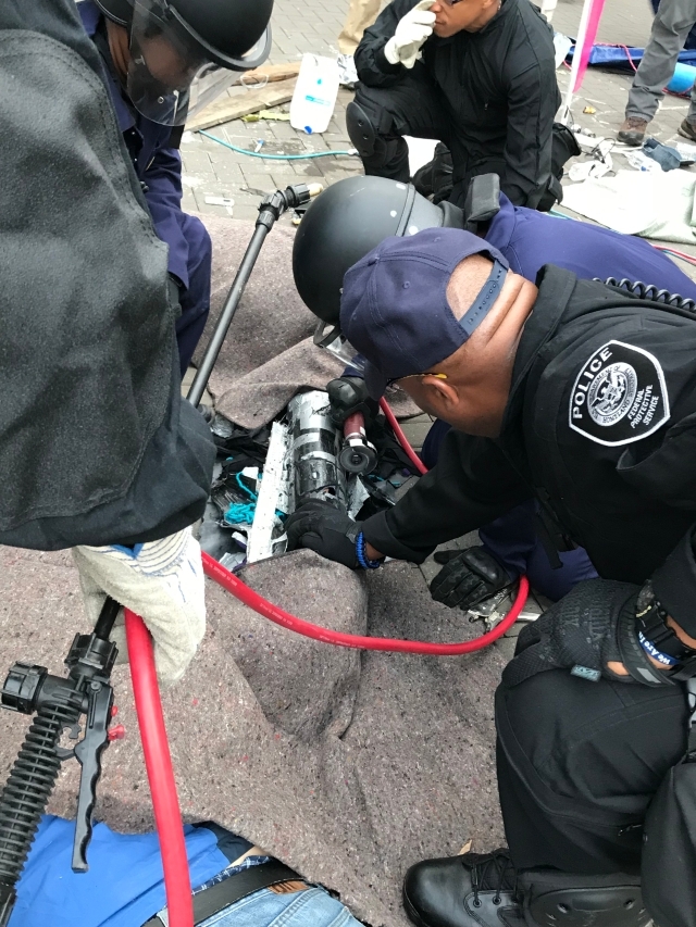 FPS Officers Separate Demonstrators Connected at Wrist by "Sleeping Dragon" Device