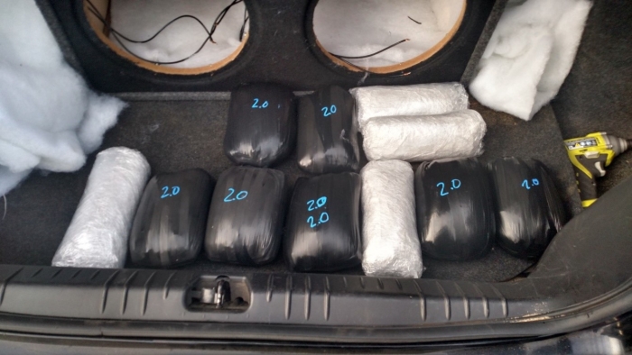 Seized meth displayed in a vehicle trunk next to the speaker box where it was recovered.