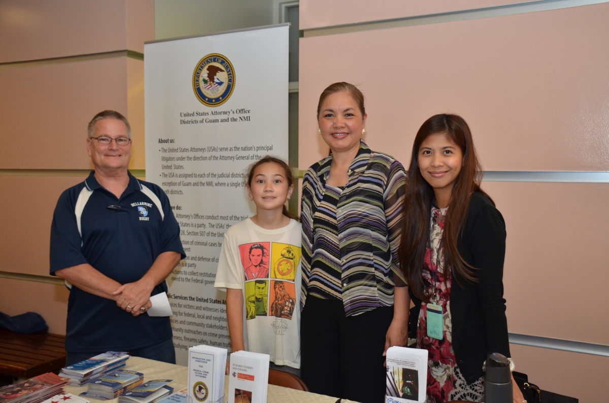 Picture of Student Clerk Jack Ruane and his daughter, with U.S. Attorney Alicia Limtiaco and Legal Assistant Roxanne Ferrer at the U.S. Attorney’s Office’s exhibit at the Law Fair held at the Judiciary of Guam