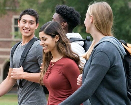 A group of diverse college students walking to class at a university.