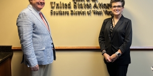 U.S. Attorney Will Thompson stands with City National Bank First Vice President-Security Officer and Senior Fraud Investigator Mary Charles in his offices at the Robert C. Byrd U.S. Courthouse in Charleston on Wednesday, June 5, 2024. The office name and seal are on the wall behind them.