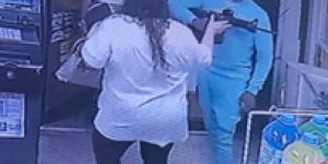 Still image of Derrick Smith Jr. with a loaded rifle inside a convenience store.