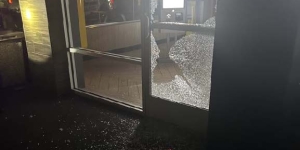 Photo of a glass door, with the bottom panel shattered.