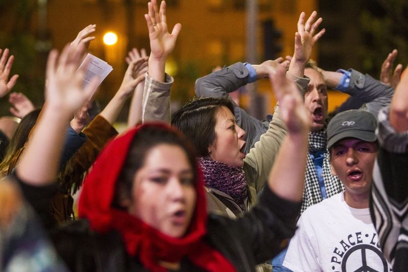 Demonstrators raise their hands during demonstrations following Michael Brown’s shooting.